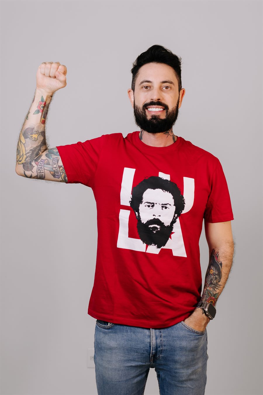 Delegado Yasser de punho erguido, vestindo camiseta vermelha do Lula