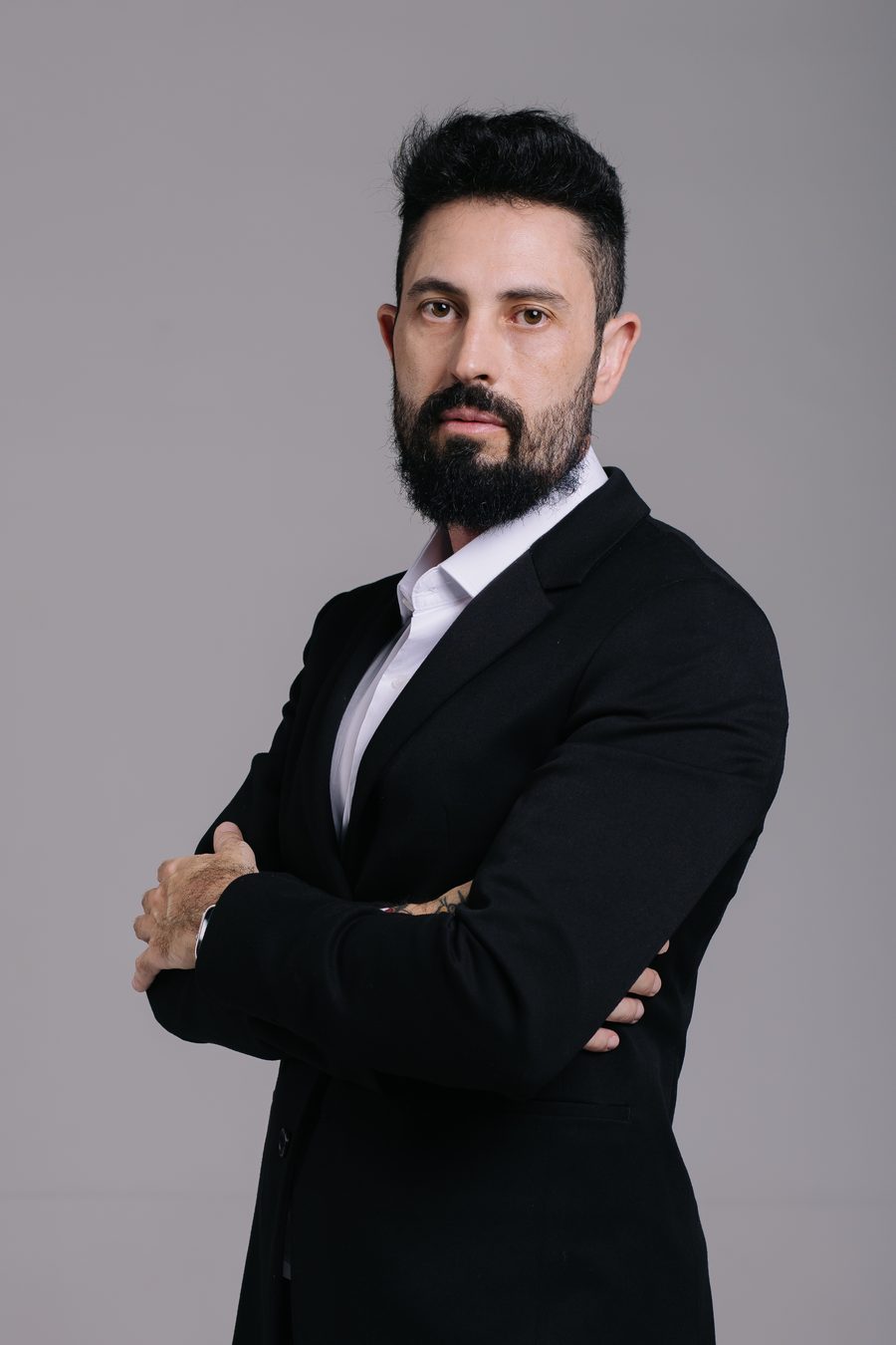 Retrato de estúdio do Delegado Yasser, de terno preto sobre camisa branca, com os braços cruzados